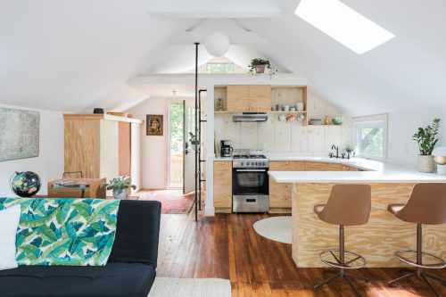 Bright, modern kitchen with wooden accents, a cozy living area, and large windows for natural light.