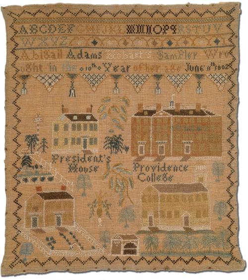 A decorative sampler featuring buildings, trees, and text, showcasing intricate needlework and historical elements.