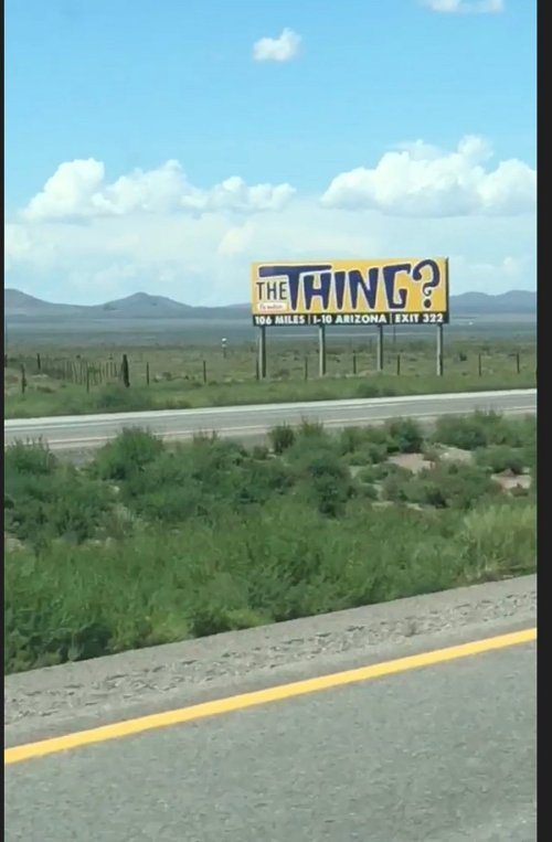 Billboard along a highway in Arizona advertising "The Thing?" with a distance of 106 miles to the attraction.