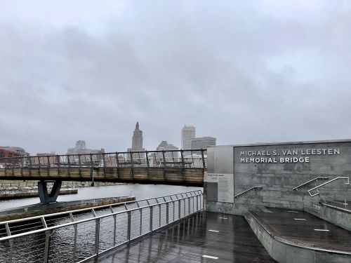 A view of the Michael S. Van Leesten Memorial Bridge over a river, with a cloudy skyline in the background.