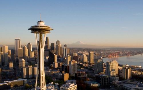 A panoramic view of Seattle featuring the Space Needle, skyline, and Mount Rainier in the background.