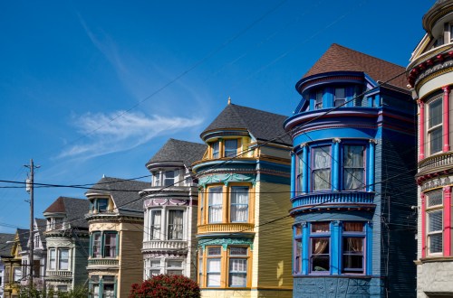 Colorful Victorian houses with ornate details under a clear blue sky.