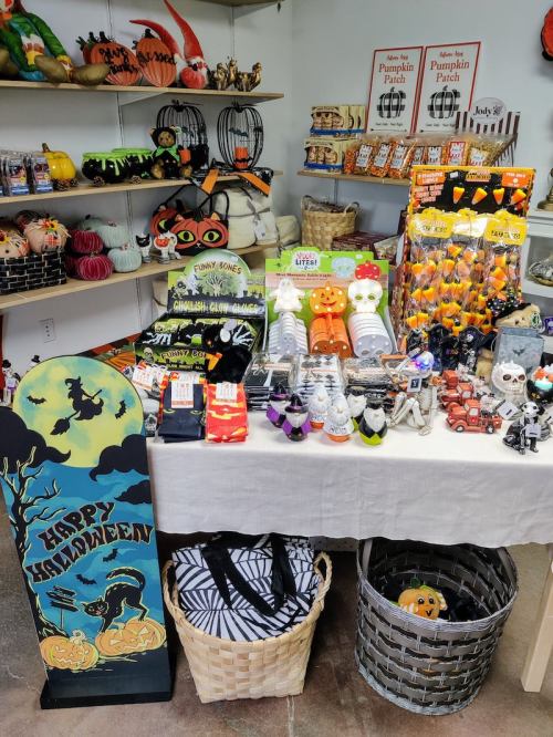 A festive display of Halloween decorations, including pumpkins, skeletons, and themed items on a table.
