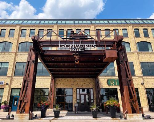 Exterior view of Ironworks Hotel, featuring a large wooden entrance and brick facade, with colorful flowers in front.