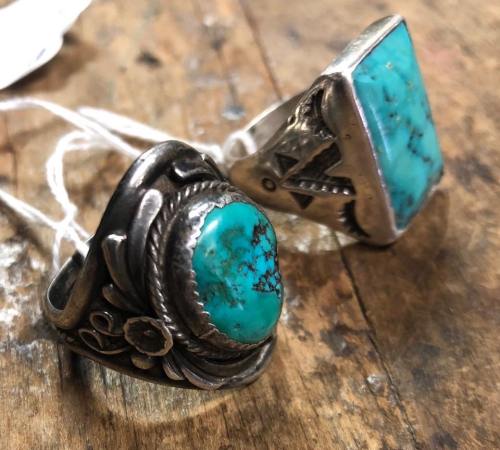 Two silver rings featuring turquoise stones, one with a floral design and the other with a geometric pattern.