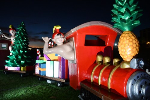 Colorful train decoration featuring playful figures and festive gifts, set against a twilight sky.