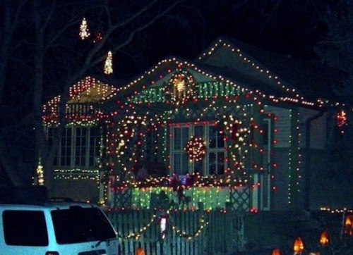 A house decorated with colorful Christmas lights, wreaths, and festive ornaments, glowing in the night.