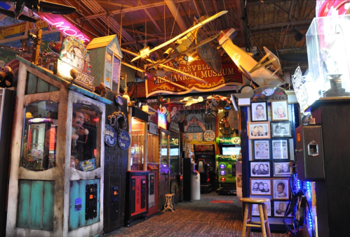 Colorful arcade with vintage games, exhibits, and a sign for the Marvelous Museum of Entertainment.