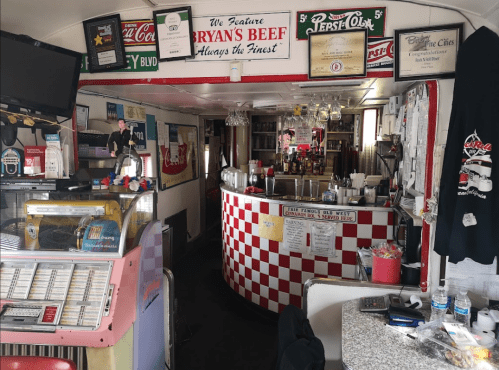A cozy diner interior featuring a checkered counter, vintage decor, and a jukebox.