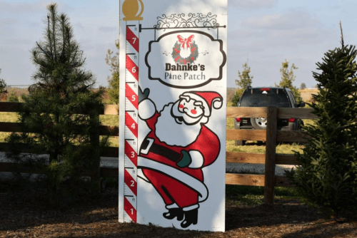 A festive sign at Dahnke's Pine Patch featuring a cheerful Santa and a height measurement scale.