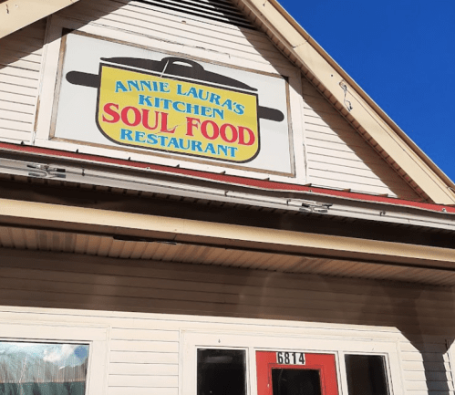 Sign for "Annie Laura's Kitchen Soul Food Restaurant" on a building with a clear blue sky above.