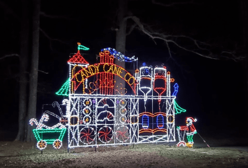 Colorful holiday lights display featuring a candy cane-themed structure with festive decorations at night.