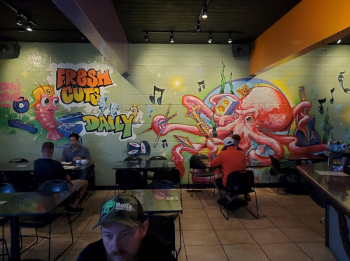 Colorful mural featuring an octopus and musical notes, with diners enjoying their meals in a casual restaurant setting.