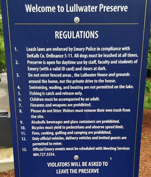 Sign at Lullwater Preserve outlining regulations for visitors, including leash laws, activities, and contact information.