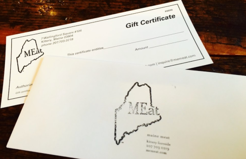 A gift certificate for MEat in Kennebunk, Maine, displayed on a wooden surface.