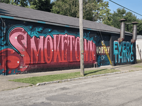 Colorful mural featuring the words "SMOKEHOUSE IS WORTHY OF EVERYTHING" on a building exterior.