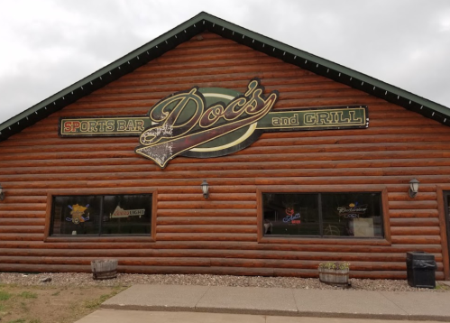 Exterior of Doc's Sports Bar and Grill, featuring a wooden log facade and a prominent sign.