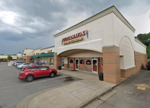 Exterior of a Mexican restaurant with a parking lot, cloudy sky, and nearby shops visible in the background.
