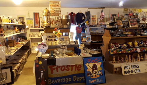 A vintage store filled with memorabilia, including signs, collectibles, and a display of retro items.