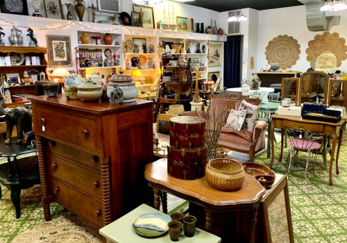 A cozy vintage shop filled with various antique furniture, decor items, and eclectic collectibles.