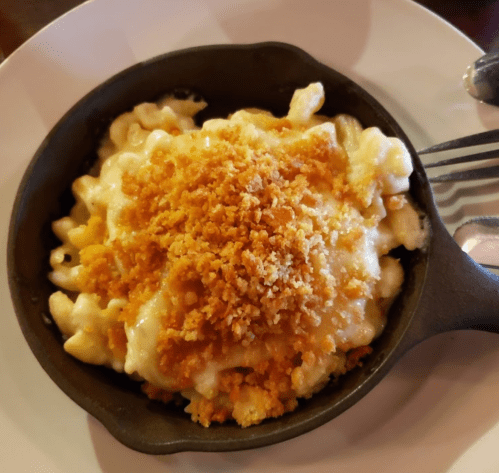 Creamy macaroni and cheese topped with crispy breadcrumbs, served in a small cast iron skillet.