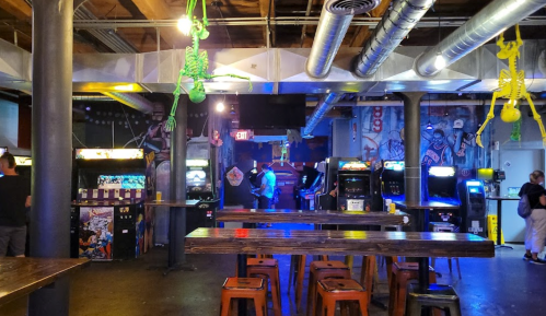 A vibrant arcade with vintage game machines, colorful decorations, and a lively atmosphere.