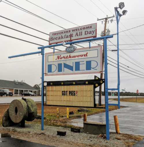 Sign for Northwood Diner with "Truckers Welcome" and "Got Pies?" displayed, set against a cloudy sky.
