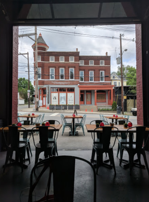 View from inside a restaurant, showcasing empty tables and a street scene with a historic building in the background.