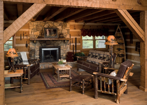 Cozy log cabin living room with rustic furniture, a stone fireplace, and warm lighting.