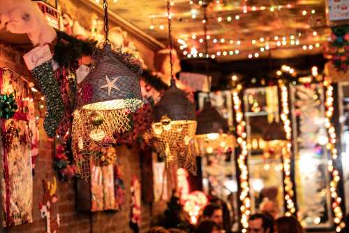 Cozy restaurant interior adorned with festive lights and decorations, featuring unique hanging lamps.