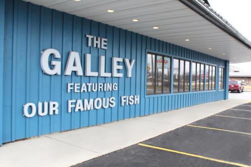 Exterior of a blue building with the sign "The Galley" and "Featuring Our Famous Fish" on the wall.