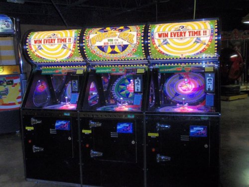 Three colorful arcade game machines with bright lights and the text "Win Every Time!" displayed prominently.