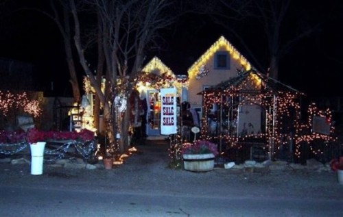 A cozy house decorated with bright holiday lights and festive decorations at night.