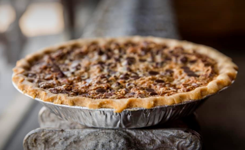 A freshly baked pie with a golden crust and a rich, textured filling, resting on a rustic surface.