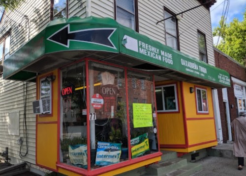 Colorful restaurant exterior with a green awning, "Freshly Made Mexican Food" sign, and an open sign in the window.
