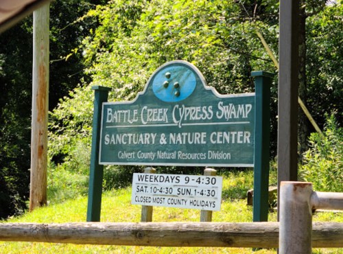Sign for Battle Creek Cypress Swamp Sanctuary & Nature Center, with hours and information about closures.