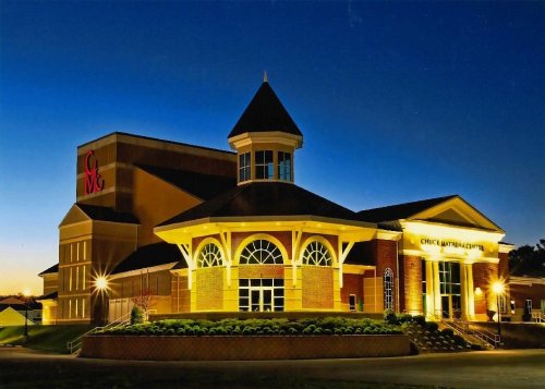 A well-lit building at dusk featuring a tower and large windows, with "CMC" signage visible.