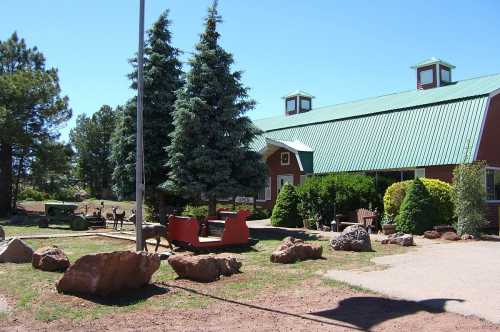 A rustic building with a green roof, surrounded by trees and rocks, featuring outdoor seating and a welcoming atmosphere.