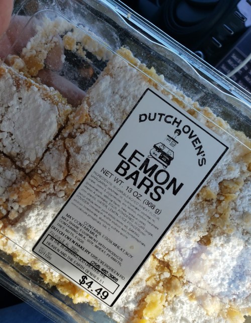 A container of Dutch Oven's lemon bars, labeled with ingredients and price, sitting in a car.