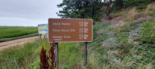 Trail sign indicating distances to Smith Tavern (2.9 km), Great Beach Hill (4.6 km), and Jeremy Point (6.5 km).