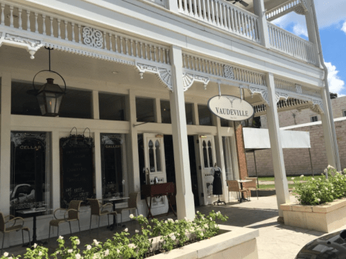 A charming storefront with a sign reading "Vaudeville," featuring large windows and decorative architecture.