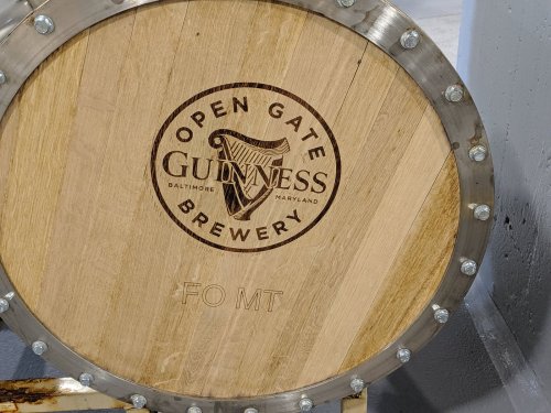 Wooden barrel with the engraved logo of Guinness Open Gate Brewery, located in Baltimore, Maryland.