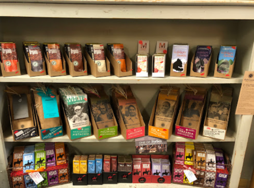 A shelf displaying various colorful chocolate bars and packaging, arranged neatly in rows.