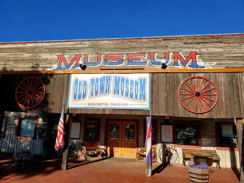 Exterior of the Old Town Museum in Burlington, Colorado, featuring wooden walls and decorative wheels.