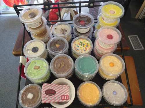 A display of colorful dessert cups in various flavors, arranged neatly on a rack.