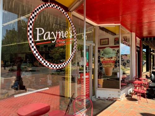 Exterior of Payne's ice cream shop with a checkered sign, colorful decor, and outdoor seating.