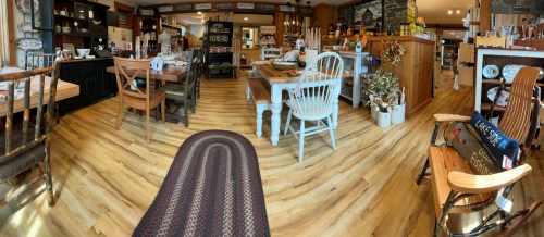 A cozy interior of a rustic shop featuring wooden furniture, decor items, and a warm, inviting atmosphere.
