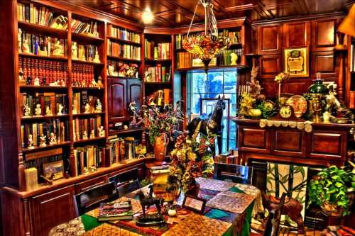 A cozy library with wooden shelves filled with books, a decorated table, and various decorative items.