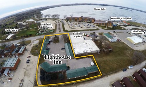 Aerial view of Lighthouse Inn and surrounding amenities, including a golf course, waterpark, and coffee shop by Storm Lake.