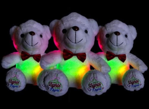 Three plush teddy bears with glowing colorful lights in their bellies, each wearing a red bow tie.